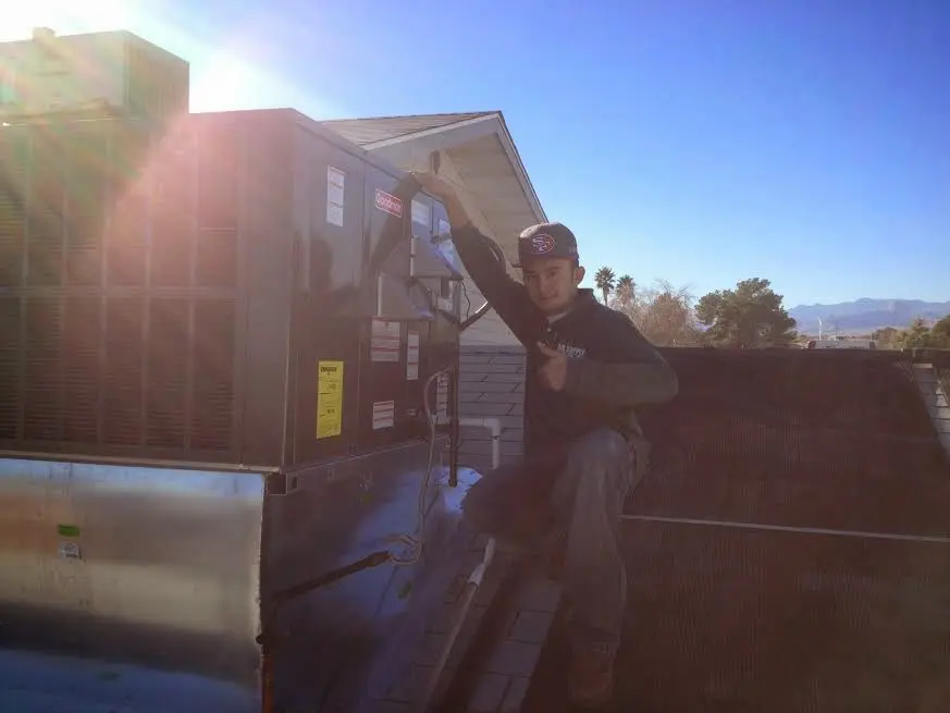 HVAC technician performing Boiler Repair on a rooftop unit in Elgin